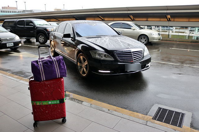 一台車和一個行李在機場外