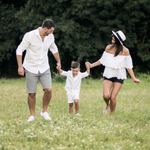 一對爸媽在草地上牽著小兒子