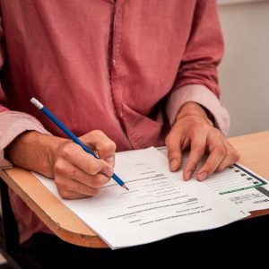 紅色衣服的人寫考試券檢定考試