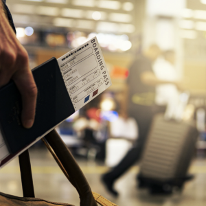 一名男子手拿著行李加上護照機票準備要出國